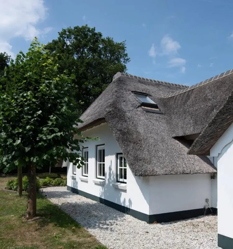 Witte villa met een rieten kap